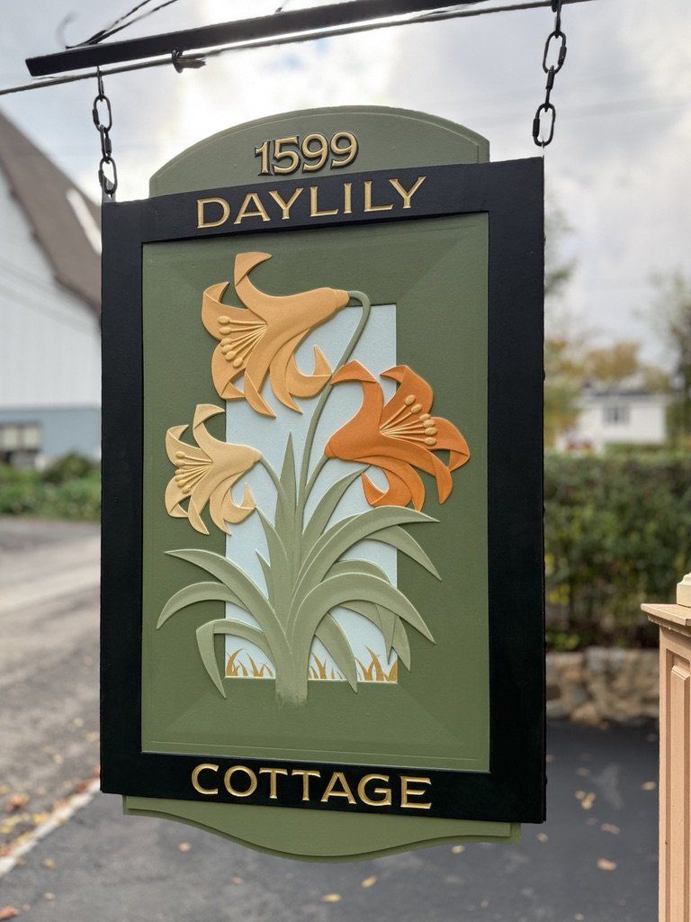 Carved and painted Daylily Cottage hanging sign with sculpted orange daylilies in a black frame