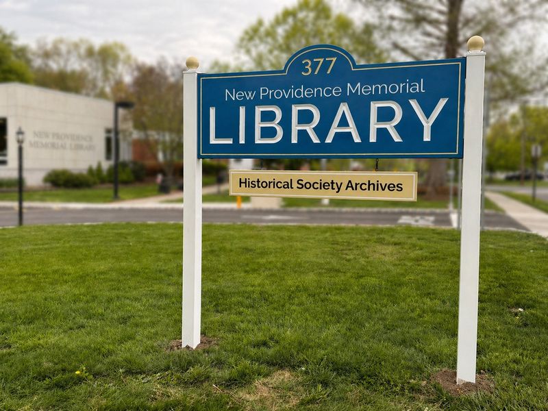 Blue and gold post and panel sign for the New Providence Memorial Library and Historical Society Archives