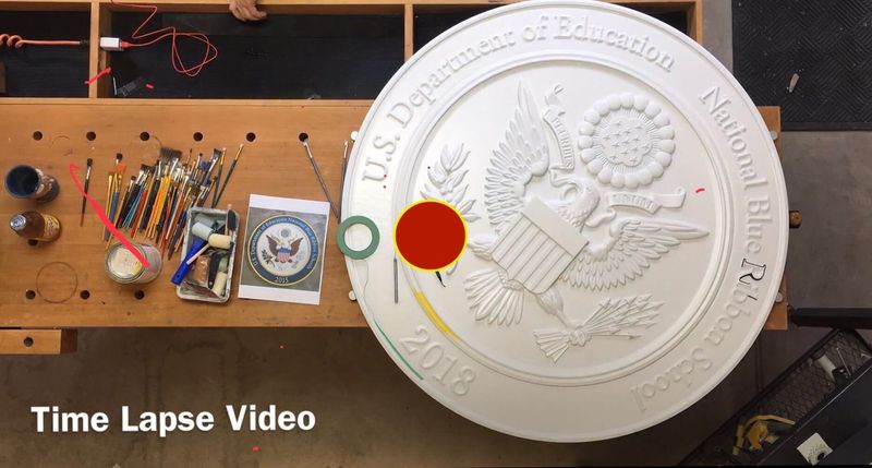 Hand painting the U.S. Department of Education National Blue Ribbon School seal carved in relief